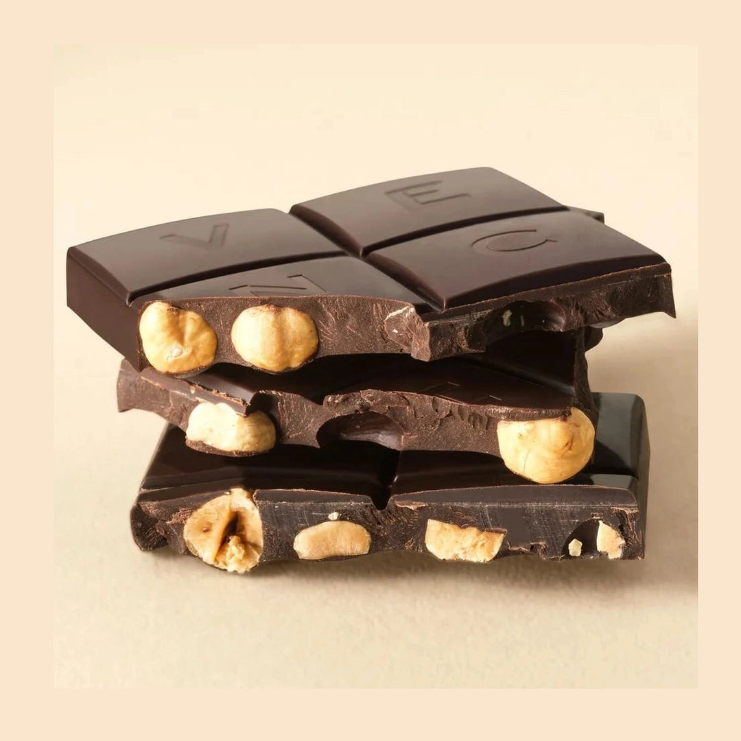 Bruten Venchi mörk choklad som visar inbäddade rostade hasselnötter