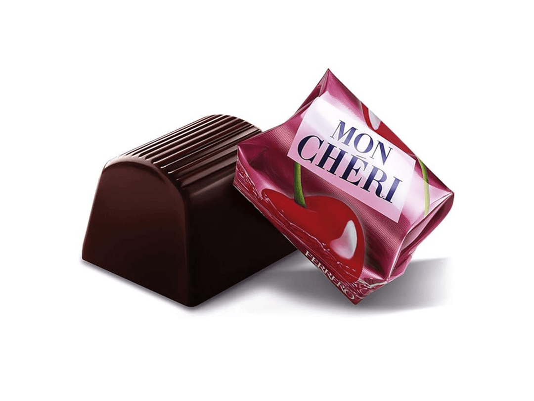 Mon Chéri körsbärslösningschoklad bit med räfflat tak bredvid rosa förpackning