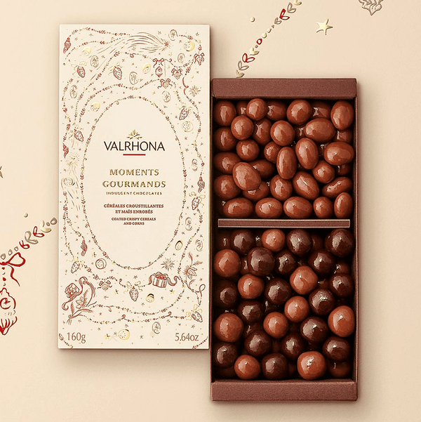Öppen Valrhona Moments Gourmands chokladask med krispiga ceralier och majs i guld- och röd juldesign
