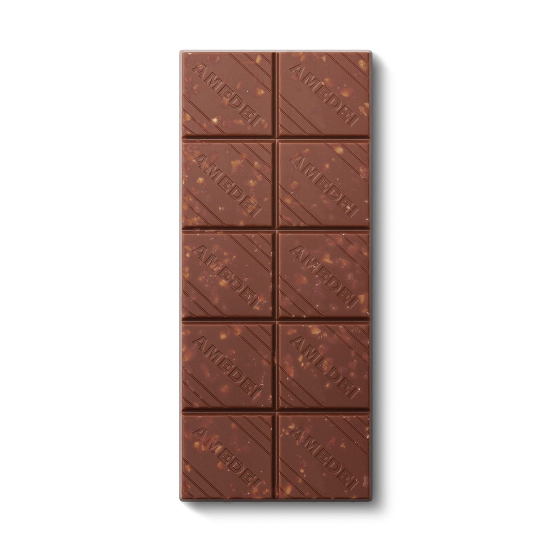 Chokladshopen Amedei Toscano Nocciola mjölkchokladkaka med hela rostade hasselnötter och präglad logotyp.