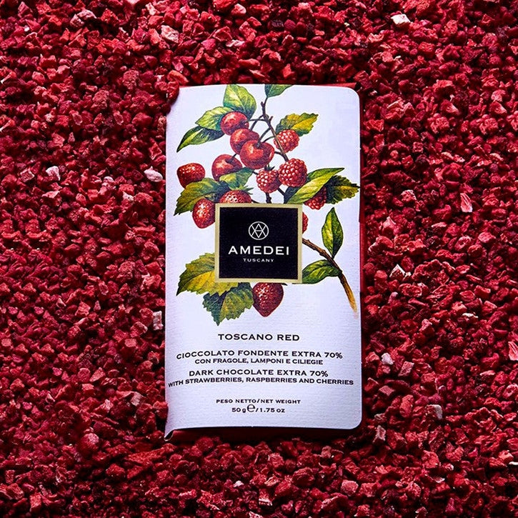 Chokladshopen Amedei Toscano Red mörk choklad 70% med frystorkade jordgubbar, hallon och körsbär på en bädd av bär.